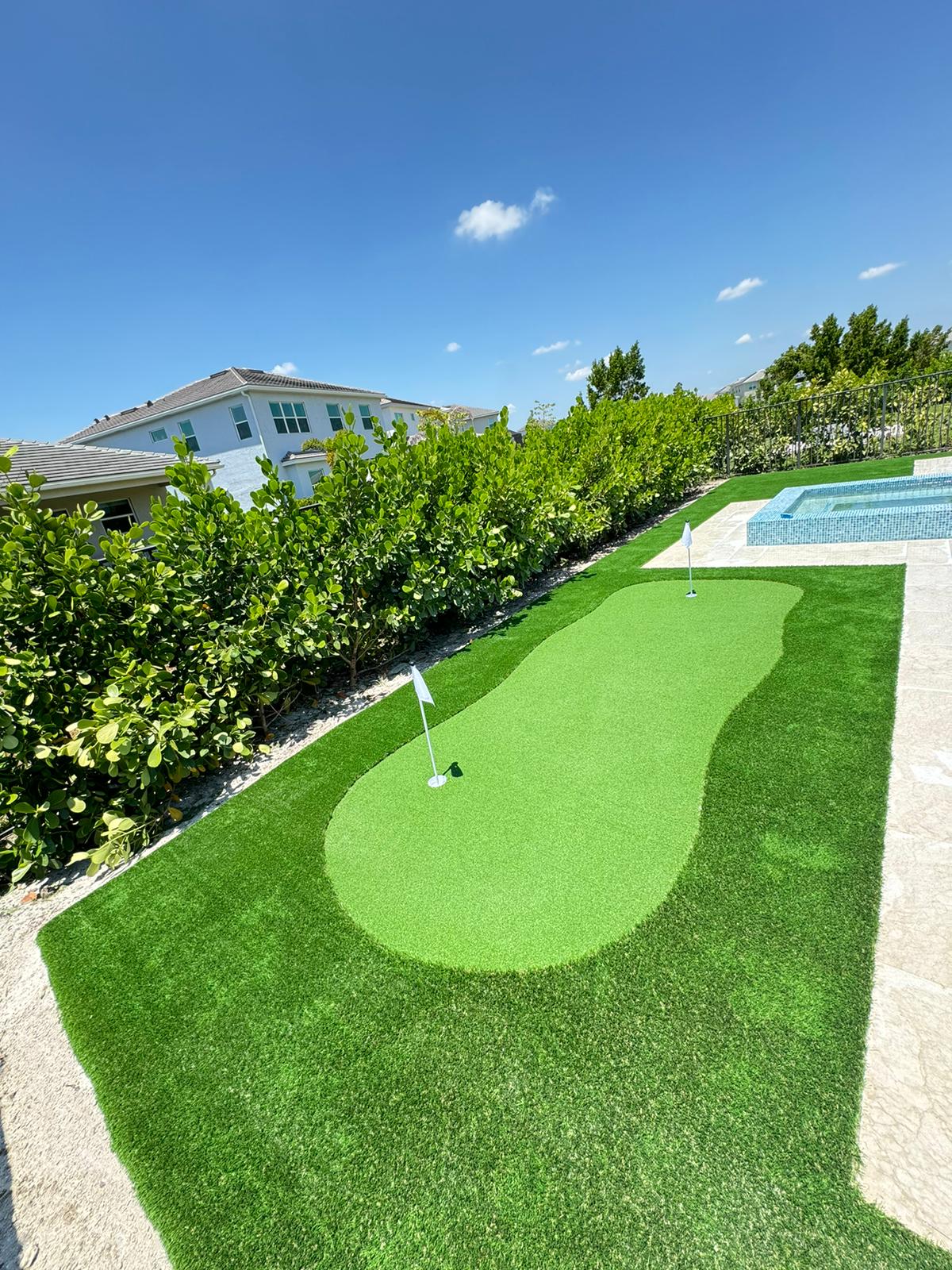 Private putting green with hedge wall